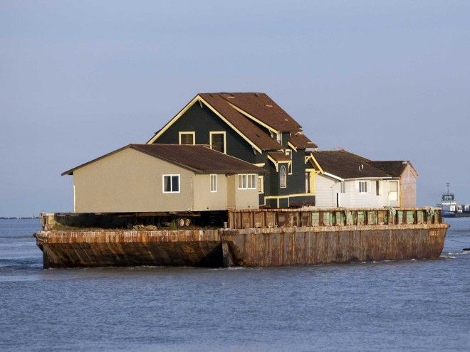 An existing home was removed by barge to make room for a separate activities building.