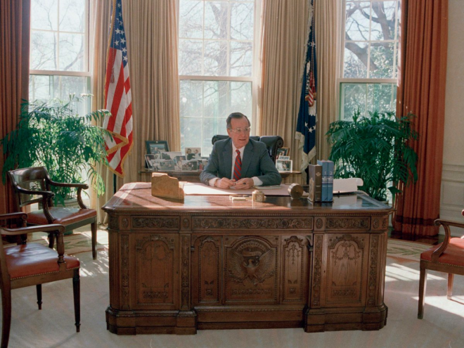 George H.W. Bush's workspace looked a bit neater, as he kept his personal photos on a table behind his desk in 1989.