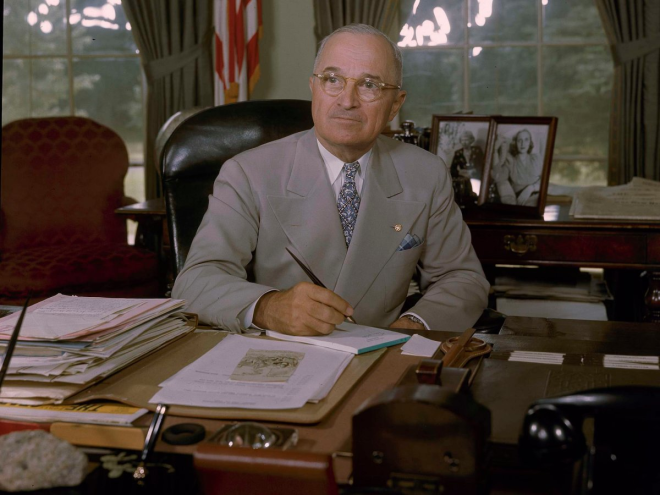 Harry S. Truman's desk also featured the familiar heaps of paper, with a table of mementos and family photos in the background.