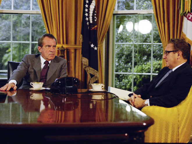 In this 1973 photo, Richard Nixon talks with Henry Kissinger over tea or coffee at his desk. On the table behind him is a bust of Abraham Lincoln, along with family photos.