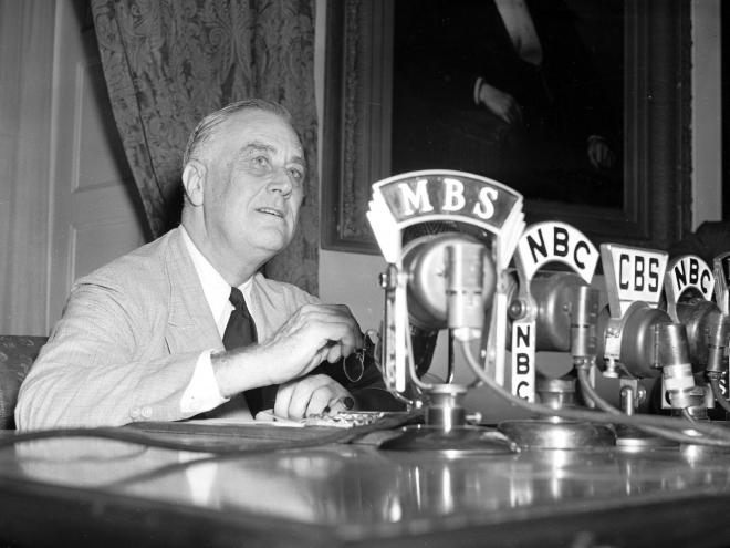 Microphones from various news outlets lined Franklin D. Roosevelt's desk as he prepared to make an announcement.