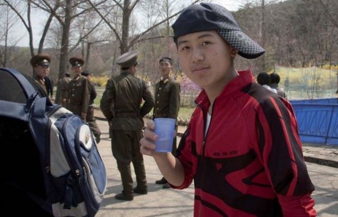 The Officials Took Issue With This Photo For Two Reasons: 1) The Teen Has His Cap Worn In A Strange Way (According To My Guide), And 2) There Are Soldiers In The Back