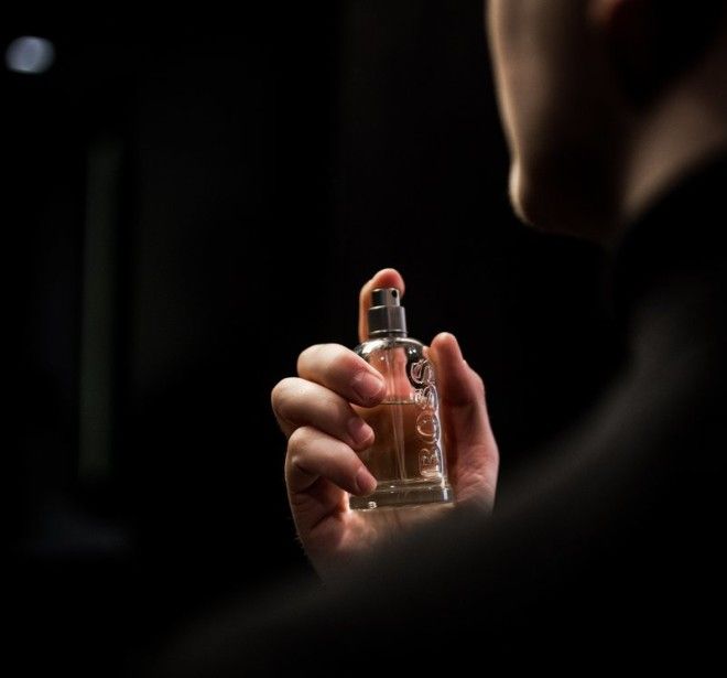 A man putting on a perfume.