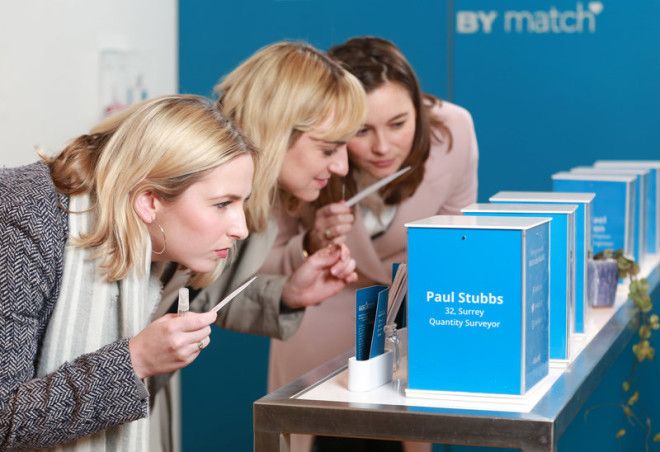 Women sniffing perfume scents of men at a dating event.