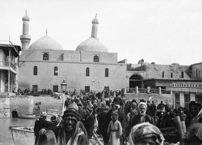 Residents of Baghdad crowd the streets.